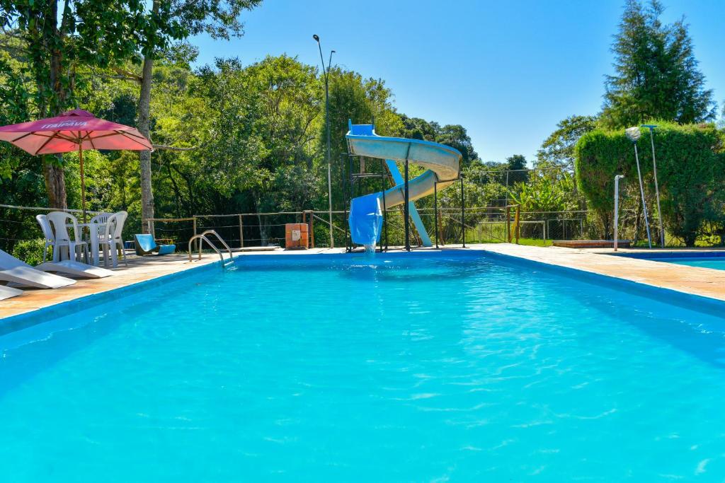 a swimming pool with a slide in the middle at CHACARA HORTOLAN in Mairinque