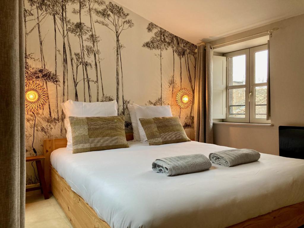 une chambre avec un lit avec deux oreillers dessus dans l'établissement L'Escale médiévale, à Carcassonne