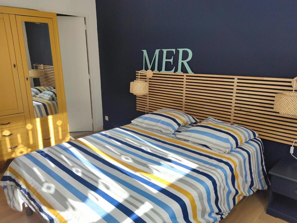 - un lit avec une couverture rayée dans une chambre dans l'établissement L'appartement Verdalle, proche de la plage de La Hume, à Gujan-Mestras