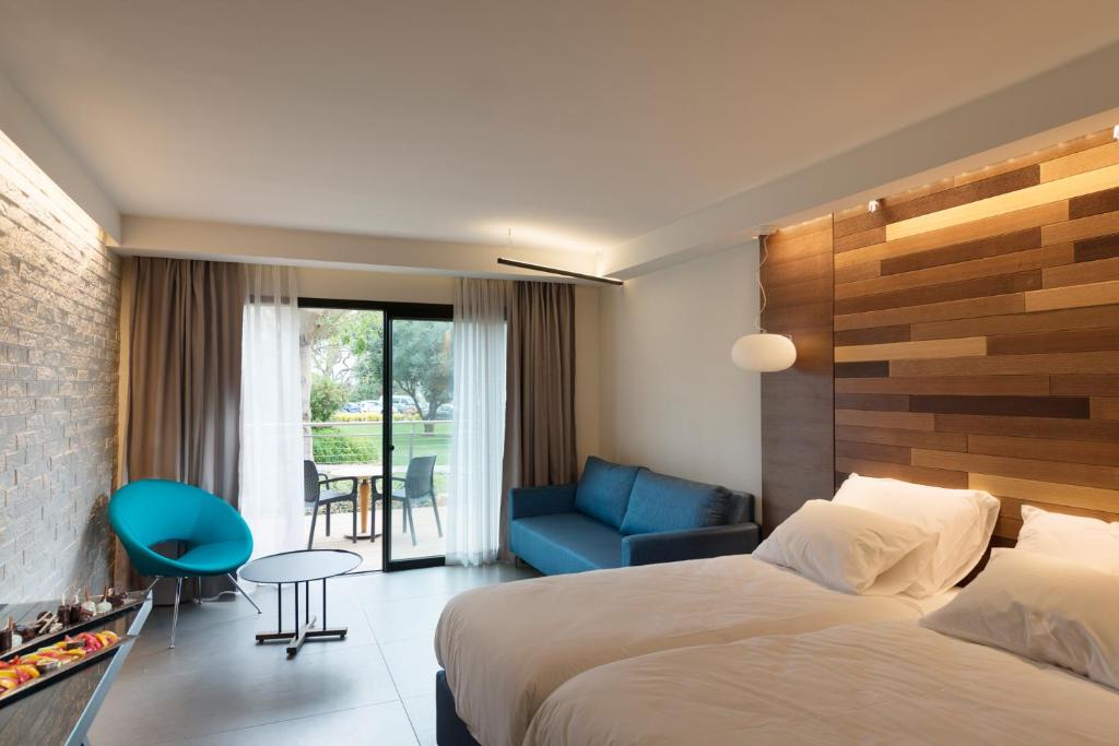 una camera d'albergo con letto e sedia blu di Shefayim Kibbutz Hotel a Shefayim
