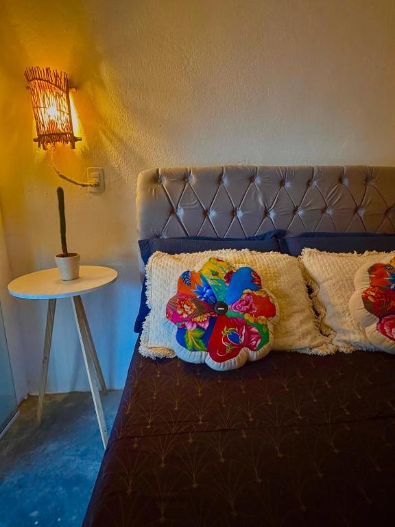 a bed in a room with a lamp and a table at Suíte 7 - Village Capixaba in Gravatá