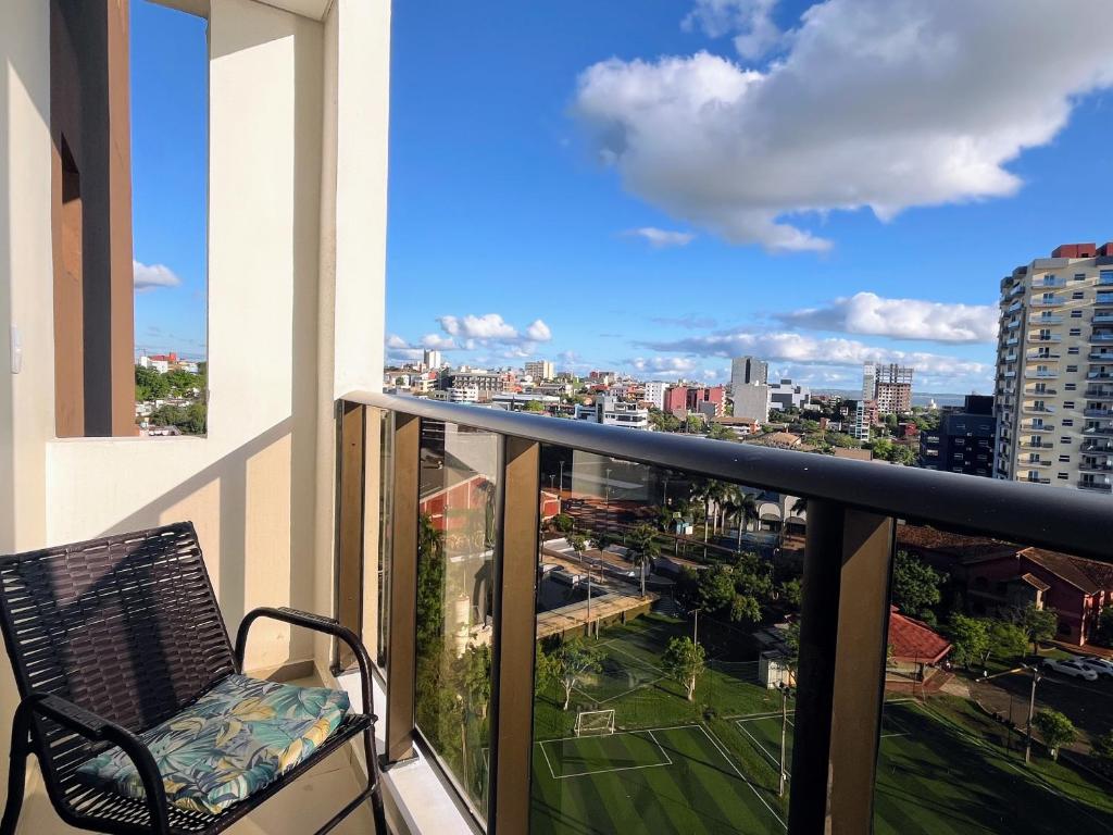 a balcony with a chair and a view of a city at Confort y estilo en cada rincón in Encarnación
