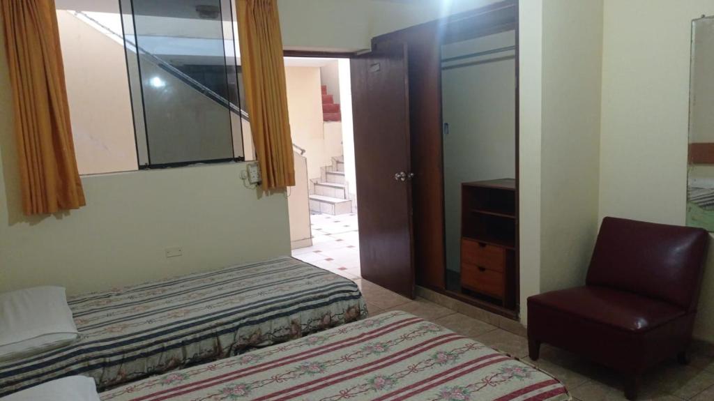 a bedroom with a bed and a chair and a window at Hotel Perseo Inn in Barranca
