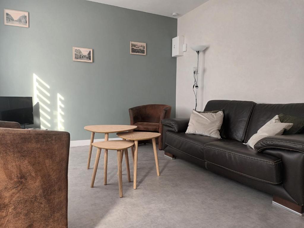 a living room with a black couch and a table at Le 289 Audruicq in Audruicq