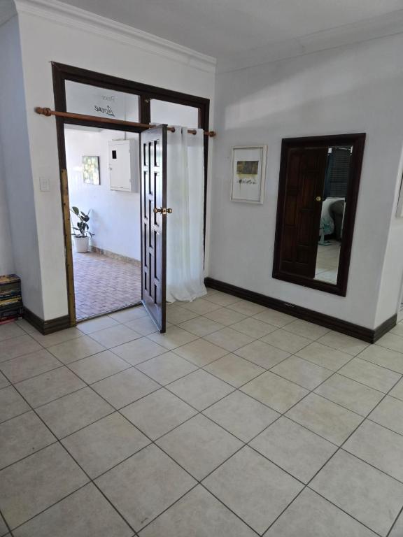 an empty room with a door and a mirror at Oasiselfcatering guest house in Vosburg