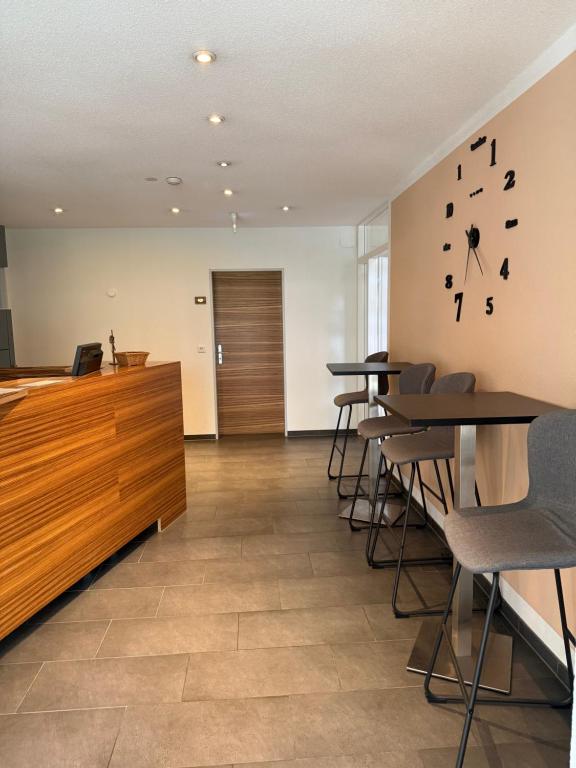 an office with tables and chairs and a clock on the wall at Hotel Schweizerblick in Bad Säckingen