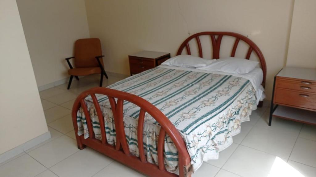 a bedroom with a bed and a dresser and a chair at Hotel Perseo Inn in Barranca