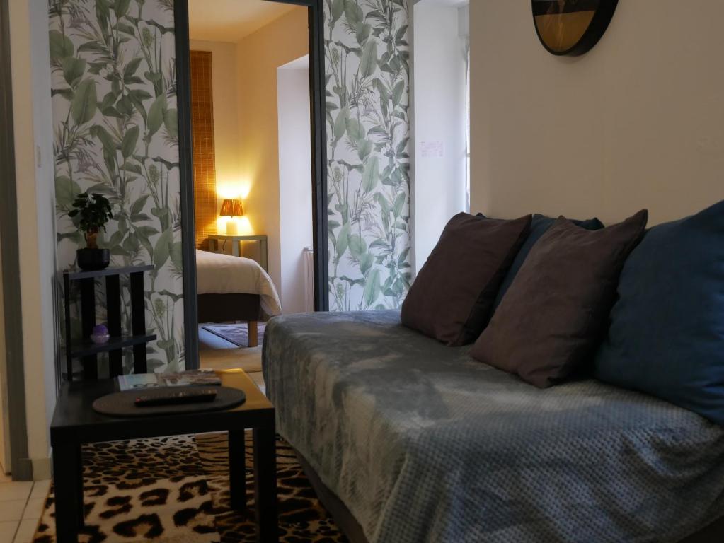 a living room with a couch and a mirror at 1690 Escale de charme près du Château de Quintin in Quintin