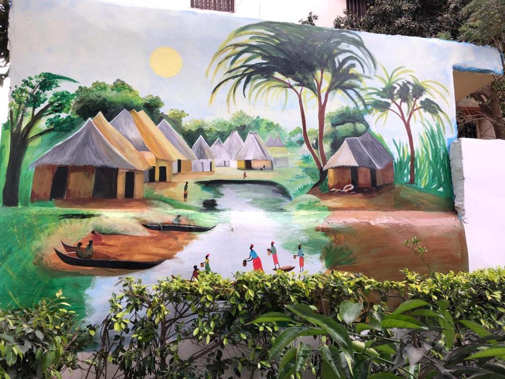 Un mural de un pueblo con gente en un río. en Villa Luxueuse à Ouakam, en Dakar