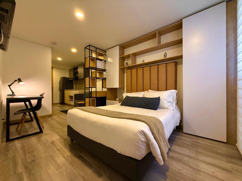 Un dormitorio con una cama grande y un escritorio. en Modern Loft in 85st near Andino, en Bogotá