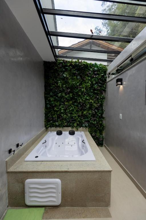 a bath tub in a room with a green wall at Casa Festival - Caminhos de OP in Ouro Preto