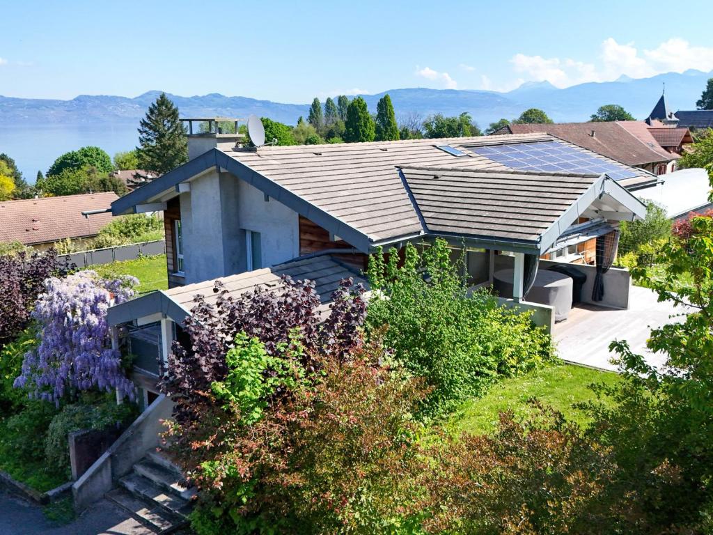 una casa con techo en la parte superior de un patio en Villa avec terrasse, jardin, proche Evian et pistes, Wifi, parking - FR-1-498-19, en Lugrin