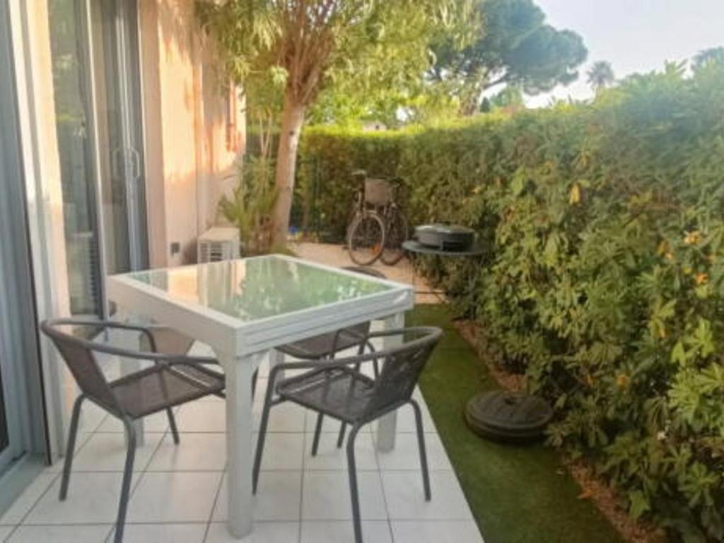 une table blanche et des chaises sur une terrasse dans l'établissement Appartement Climatisé avec Terrasse, Piscine et Parking, à 700m de la Plage à Argelès-sur-Mer - FR-1-776-4, à Argelès-sur-Mer