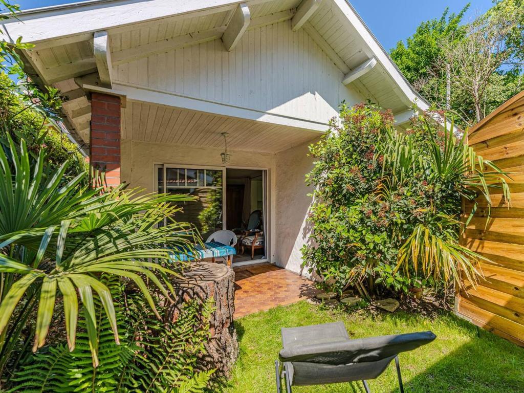 une maison avec un jardin et une chaise dans la cour dans l'établissement Arcachon : Dépendance Charmante à 400 m de la Plage - FR-1-433-140, à Arcachon