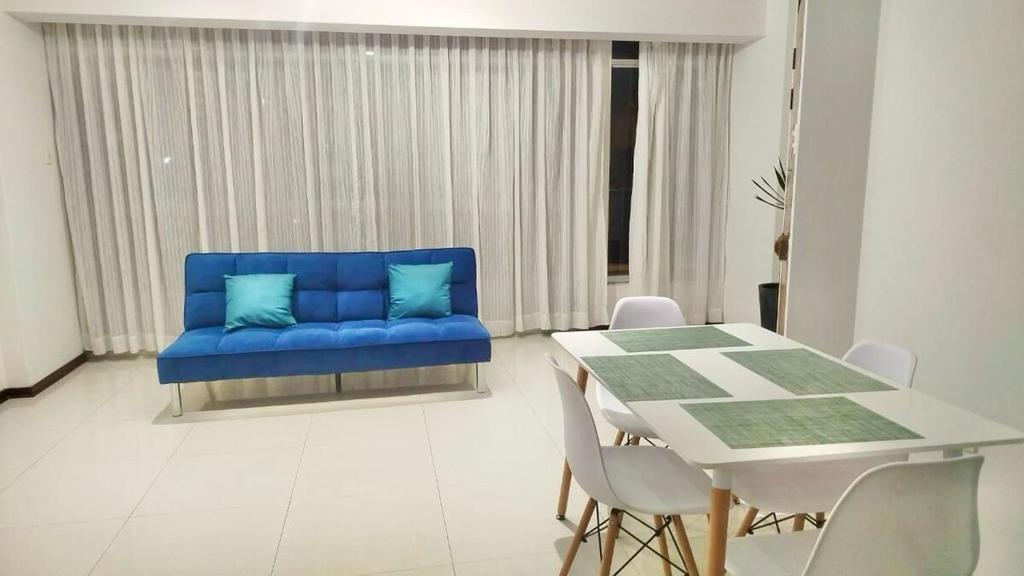 a blue couch in a living room with a table at Nuevo Lanzamiento, Urbanizacion San Andres, frente a parque in Trujillo