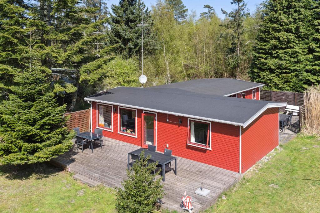 une maison rouge avec un toit noir sur une terrasse dans l'établissement Charming Holiday Home In Peaceful Surroundings, à Gedser