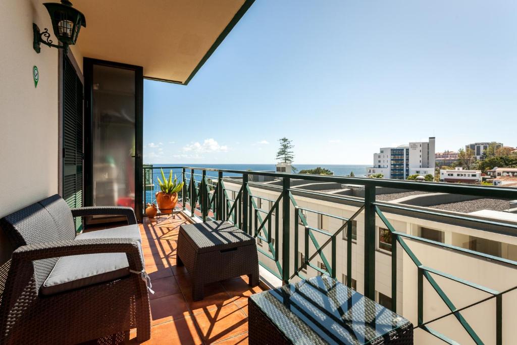 Un balcón con sillas y vistas al océano. en Apartamento Princesa Madeira, en Funchal
