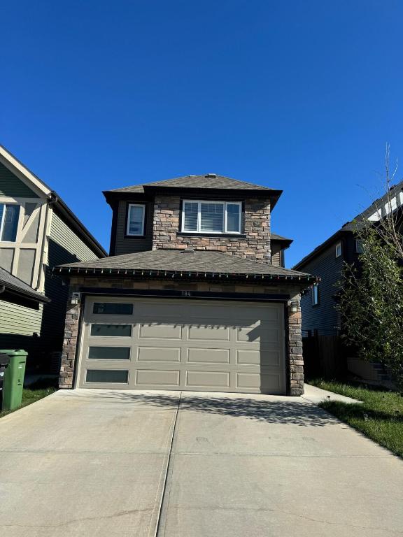 a house with a garage door and a driveway at Exquisite Entire 4- Bed rooms vacation home! in Calgary