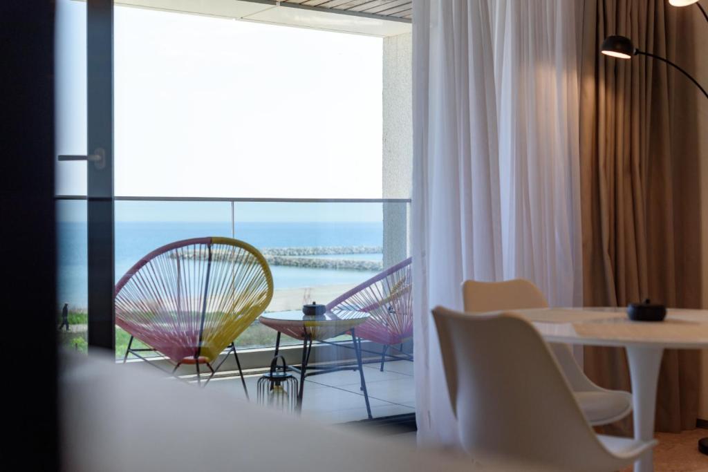 a room with a table and chairs and a view of the ocean at Astria Siena - Complex Novum in Olimp