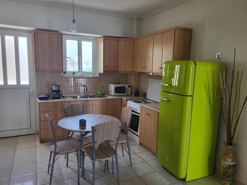 a kitchen with a green refrigerator and a table at Kalamata Apartment Beach Front in Kalamata