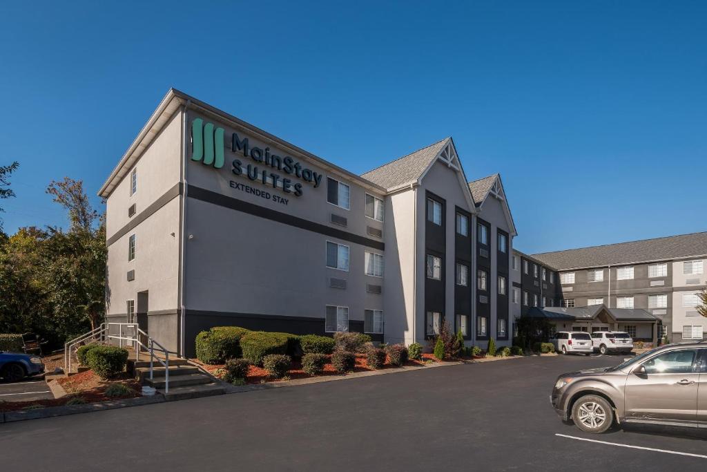 a building with a car parked in a parking lot at MainStay Suites Chattanooga Hamilton Place in Chattanooga