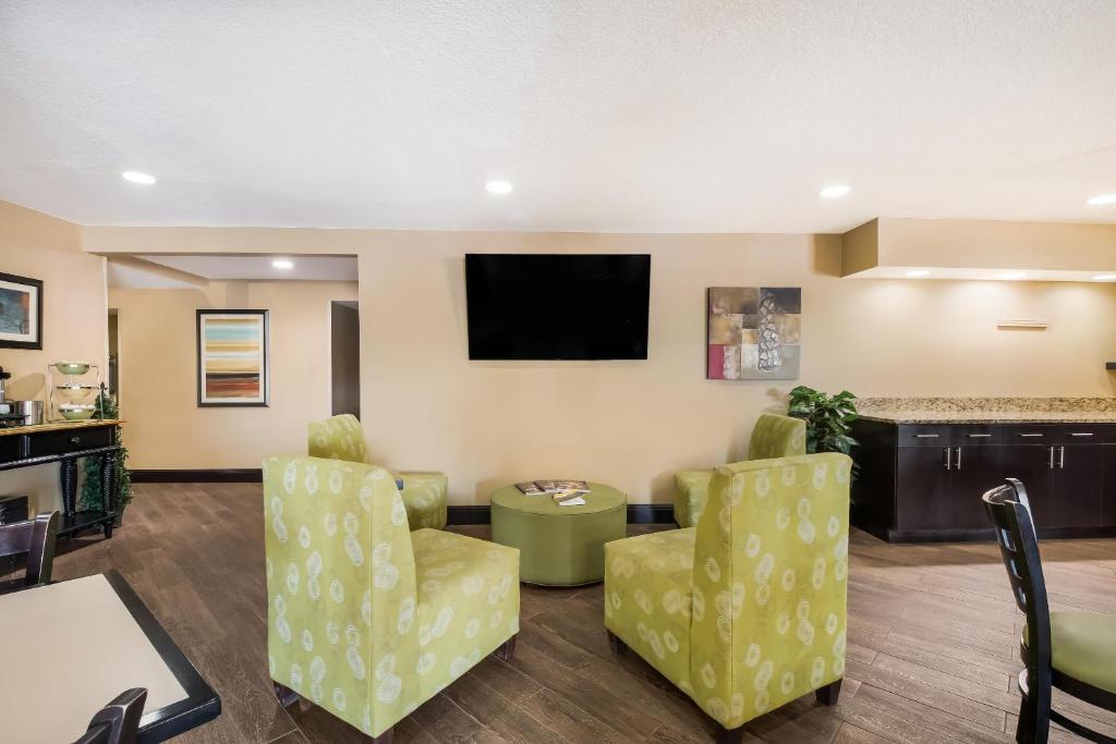 a living room with a flat screen tv and chairs at MainStay Suites Chattanooga Hamilton Place in Chattanooga