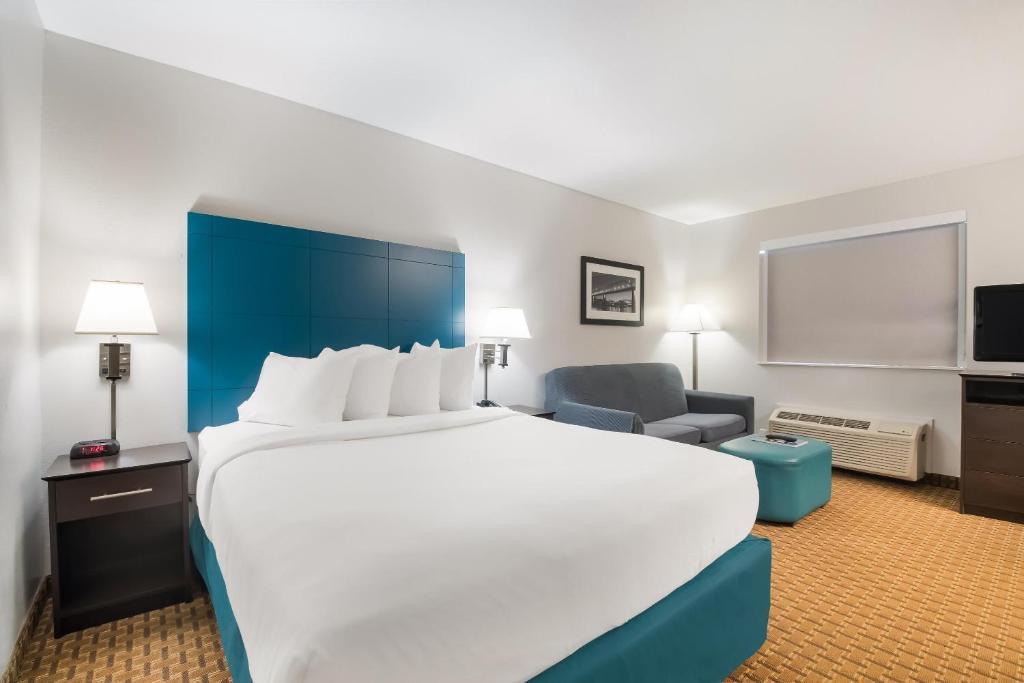 a hotel room with a large bed and a chair at MainStay Suites Chattanooga Hamilton Place in Chattanooga