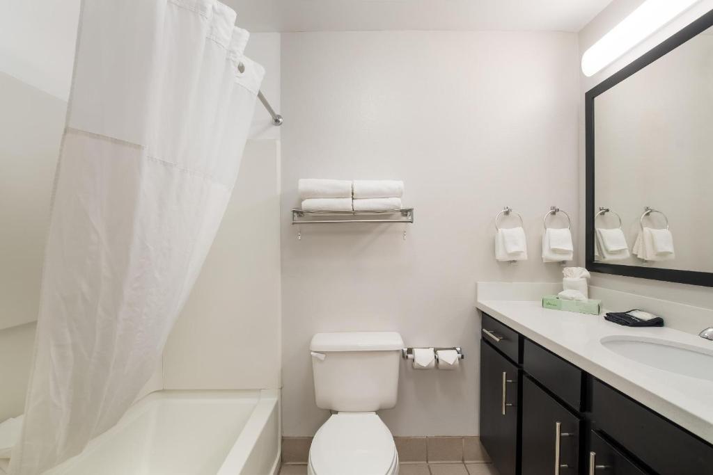 a white bathroom with a toilet and a sink at MainStay Suites Chattanooga Hamilton Place in Chattanooga