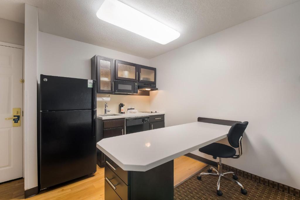 a kitchen with a white counter and a black refrigerator at MainStay Suites Chattanooga Hamilton Place in Chattanooga