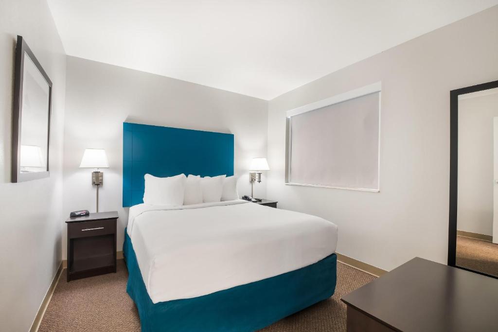 a hotel room with a large bed with a blue headboard at MainStay Suites Chattanooga Hamilton Place in Chattanooga