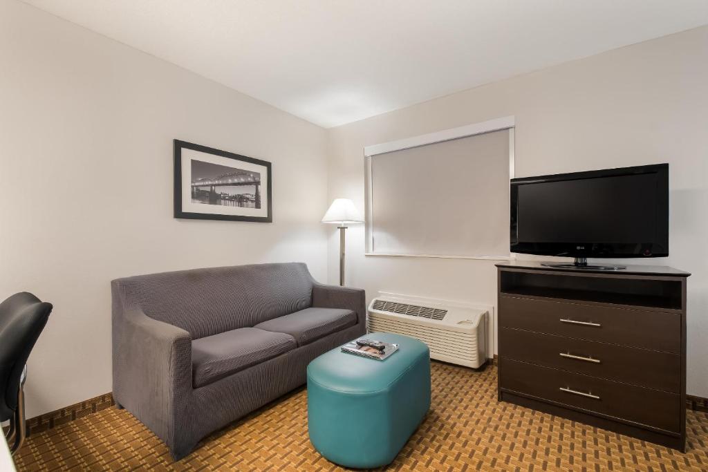 a living room with a couch and a flat screen tv at MainStay Suites Chattanooga Hamilton Place in Chattanooga