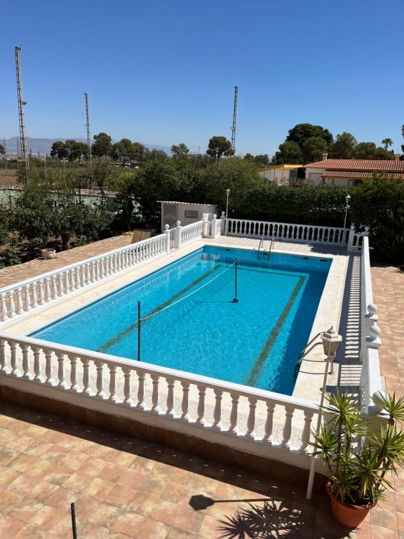 a swimming pool with a white fence around it at La casa de mamá in Lorca