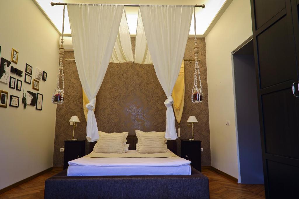 a bedroom with a bed with a canopy and curtains at Arina Apartments 2 in Braşov