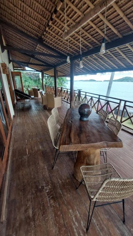 a large wooden table and chairs on a deck at Lombok Villas, Villa KuraKura in Labuhanpoh