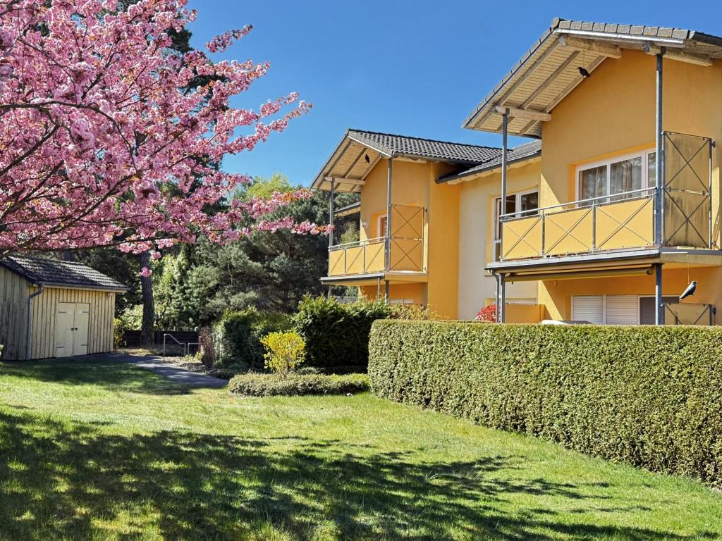 une maison avec un arbre à fleurs dans la cour dans l'établissement Ferienwohnung Melosine, à Ostseebad Koserow