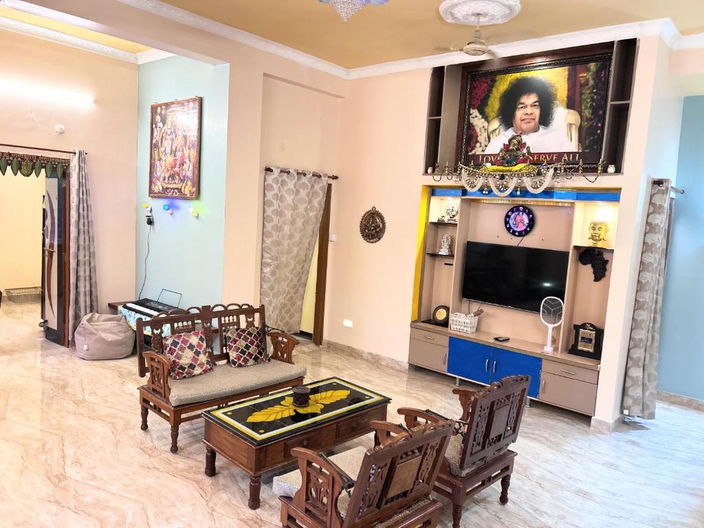 a living room with a couch and a tv at Green Serene Estate & home-stay in Puttaparthi