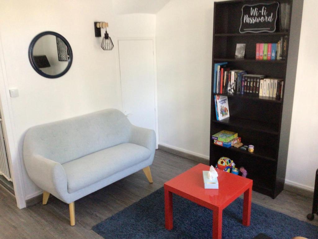 un salon avec une chaise bleue et une table rouge dans l'établissement Sara's Home 24, à Rouen