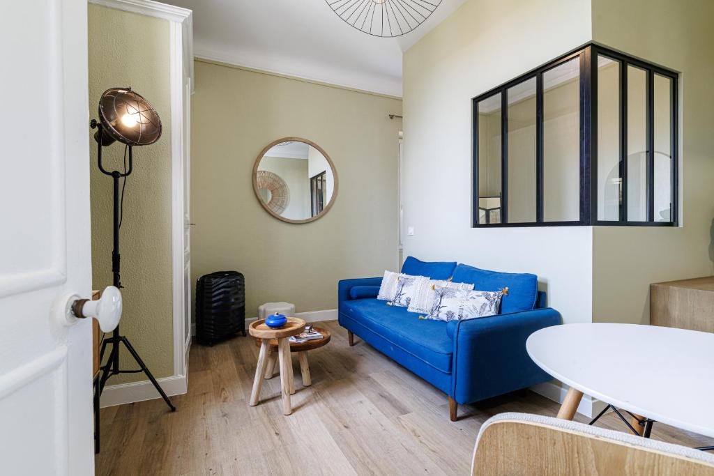 un salon avec un canapé bleu et une table dans l'établissement Lueur Provençale, à Villeneuve-Loubet