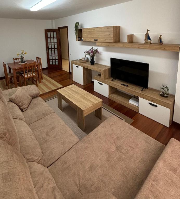 a living room with a couch and a flat screen tv at Apartamento Barbanza Arousa in Boiro