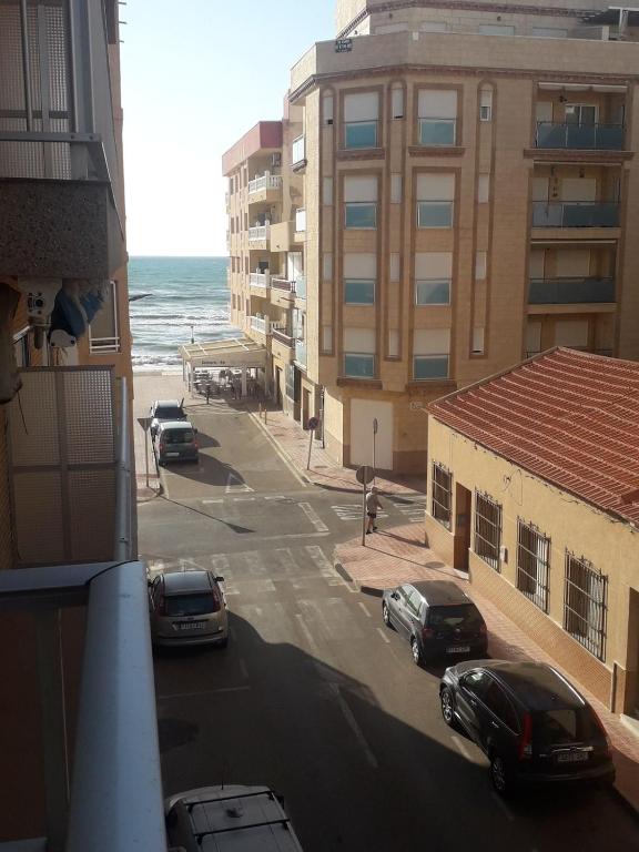 a view of a street with parked cars and the ocean at La Mata relax in La Mata