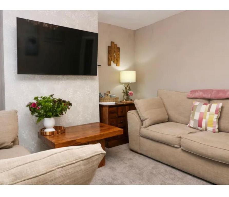 a living room with a couch and a tv at Willow Cottage Haverigg Millom in Haverigg