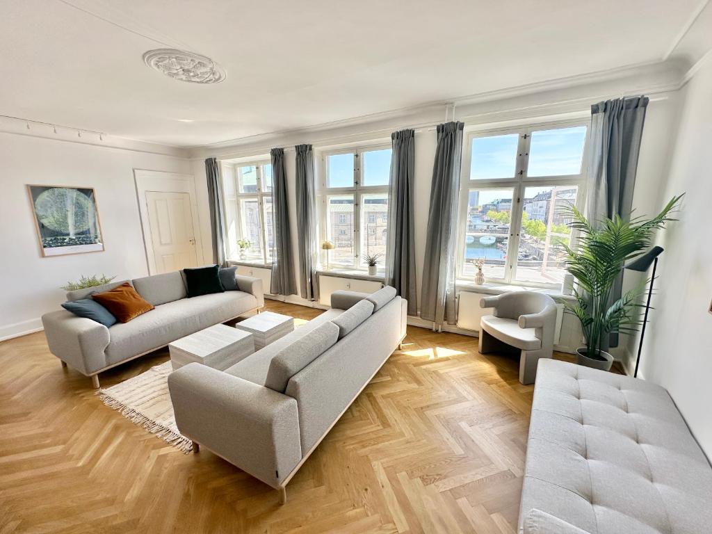 a living room with two couches and a large window at Deluxe 4 Bedrooms 180 m2 Canal View Prime Location in Copenhagen