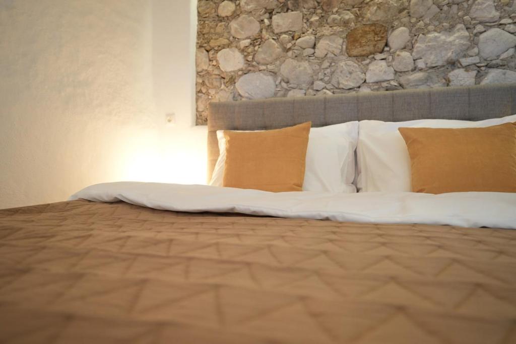 a bed with pillows and a stone wall at Appartement Am-Wildpfad in Bad Goisern