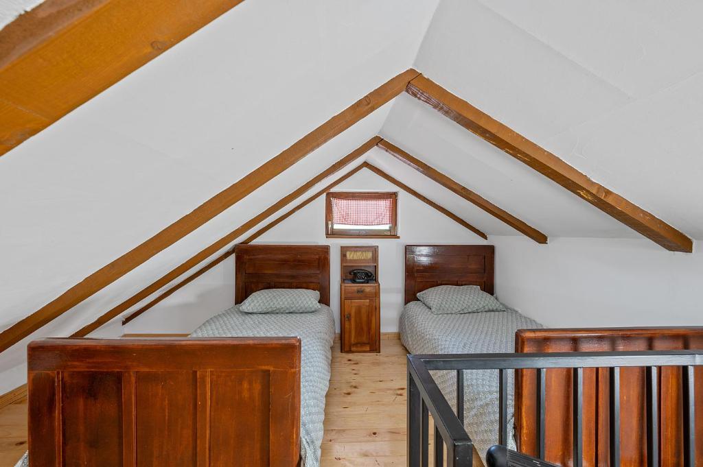 a attic room with two beds and a staircase at Village House Belec in Belec