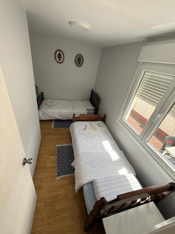 オ・ポリーニョにあるCasa Solのベッドが2つと窓がある小さな部屋