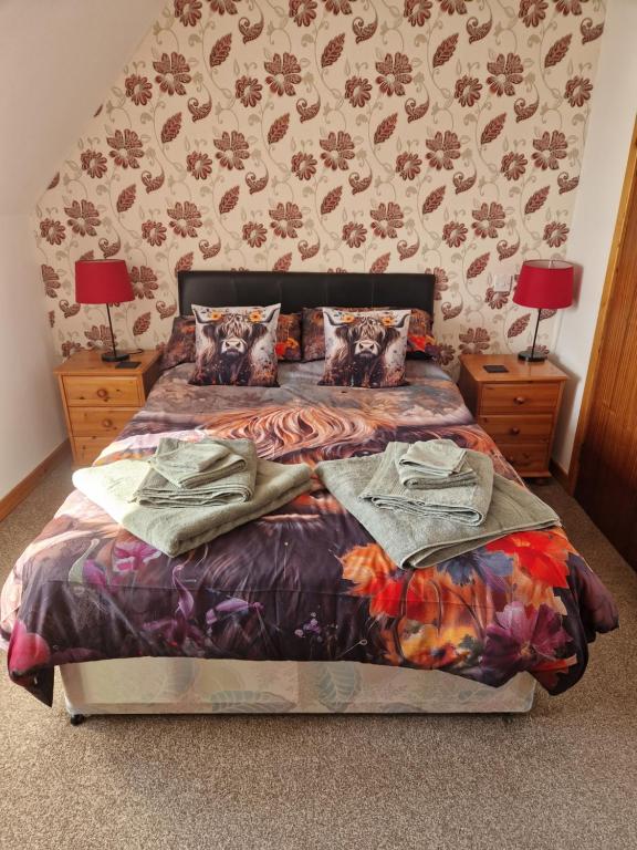 a bedroom with a bed and two night stands with lamps at The harbour inn in Burghead