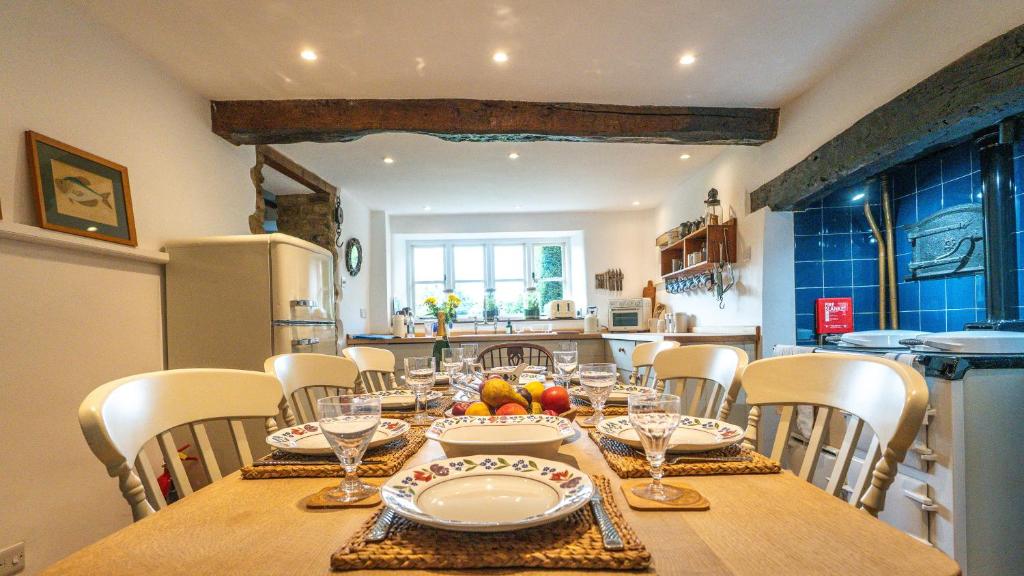 une salle à manger avec une table et des chaises en bois dans l'établissement Stunning 4-Bed Thatched Cottage in Oxfordshire!, à Ledwell