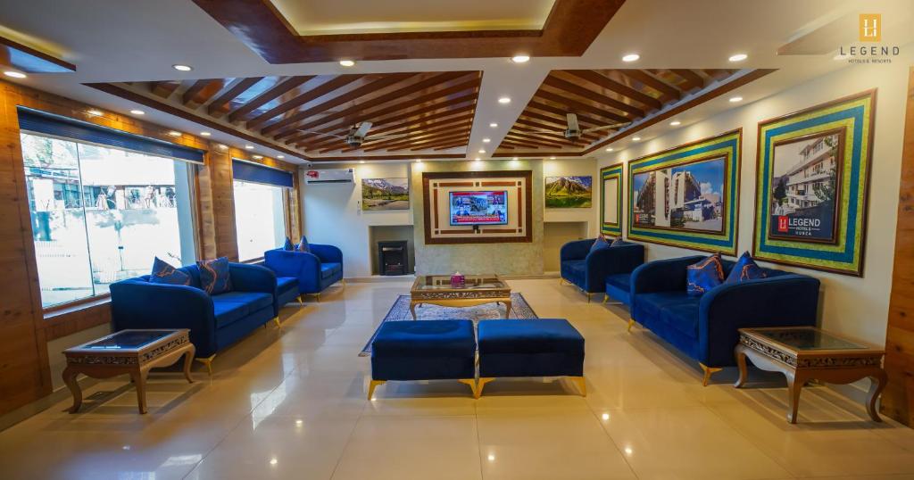 a waiting room with blue chairs and a table at Legend Hotel Skardu in Skardu