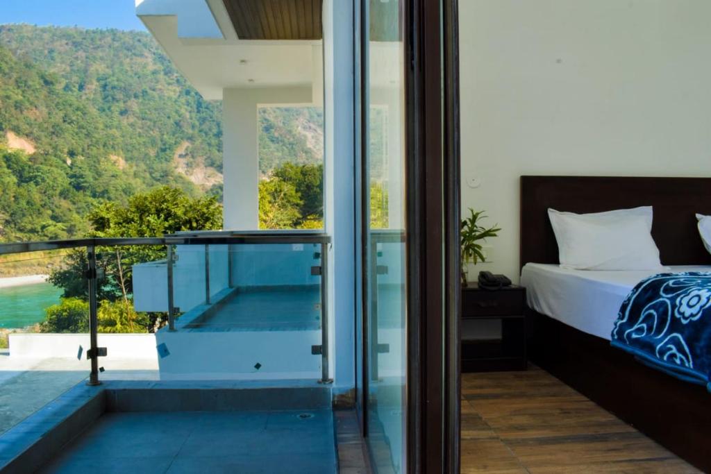 a bedroom with a bed and a balcony with a view at Phool Chatti Yoga Ashram 7 day Yoga Retreat in Shivpuri