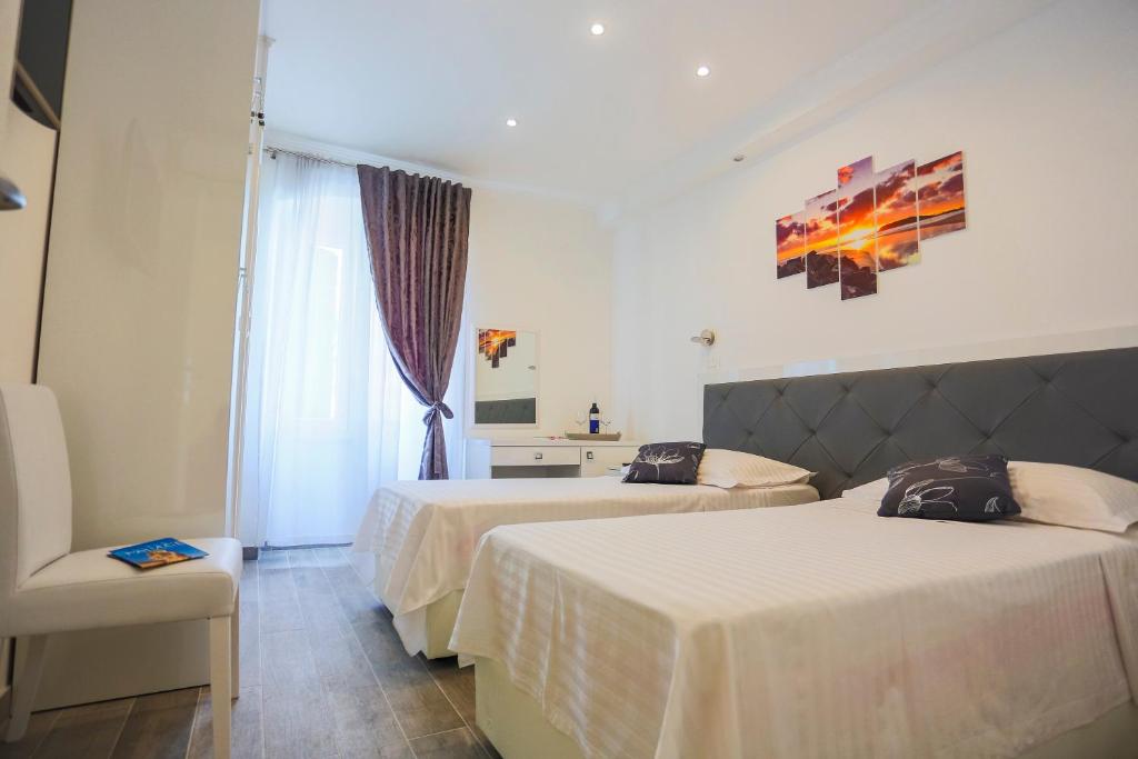 une chambre d'hôtel avec deux lits et une chaise dans l'établissement Nirvana rooms Split, à Split